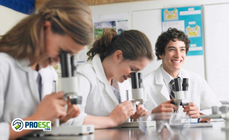 Estudantes do Novo Ensino Médio com microscópios em um laboratório de biologia