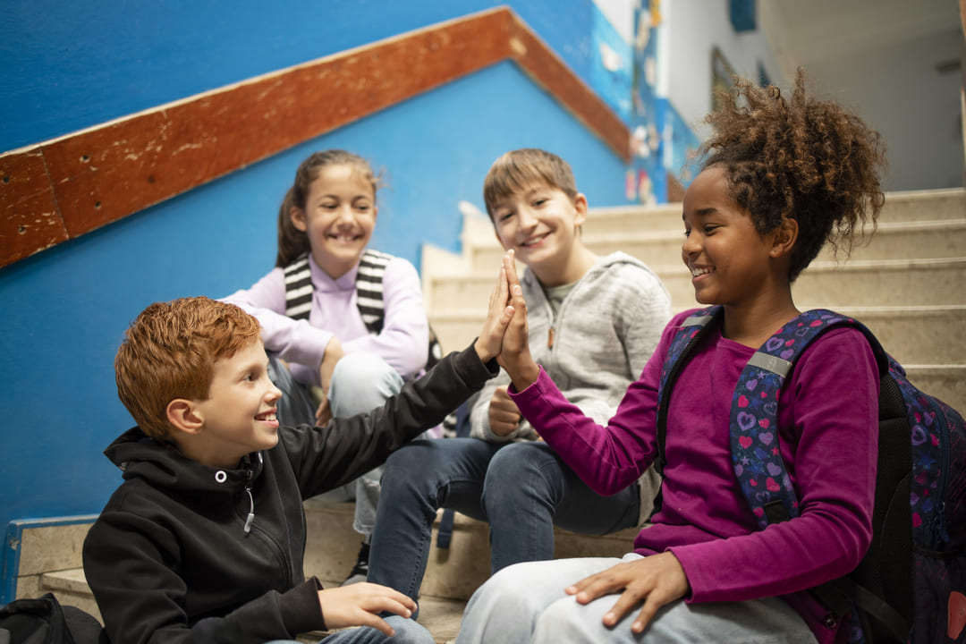 Estudantes reunidos e dando as mãos, representando a diversidade na escola.