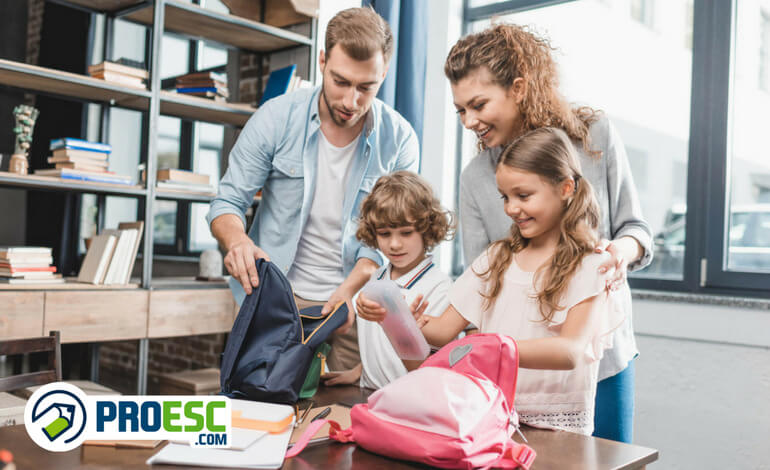 Pais arrumando as mochilas dos filhos para a matrícula na escola