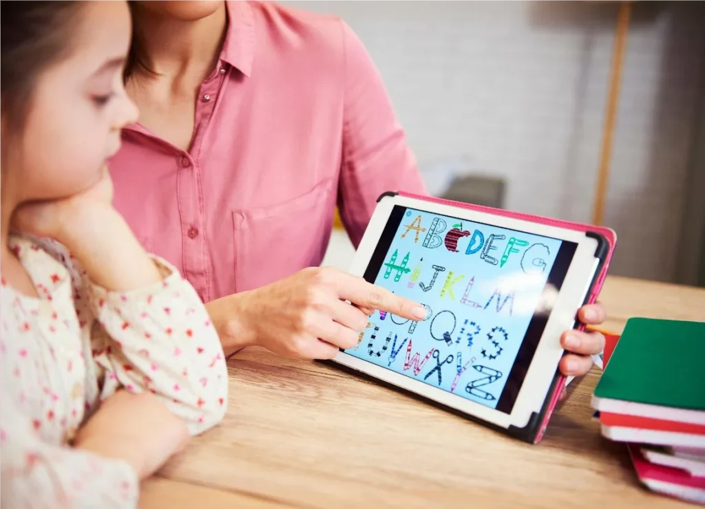 Mãe ensinando o alfabeto para filha através do método de alfabetização digital