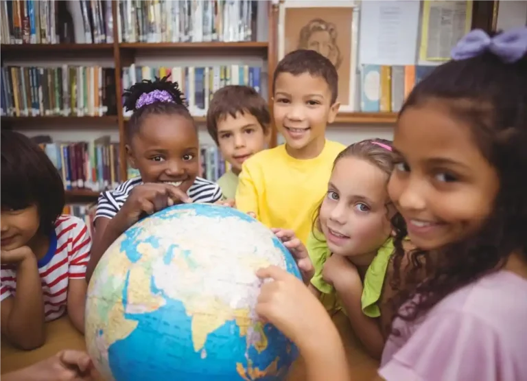 Crianças segurando globo com mapa mundi e aprendendo sobre diversidade cultural