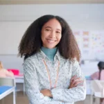 Professora sorridente em sala de aula durante o período letivo