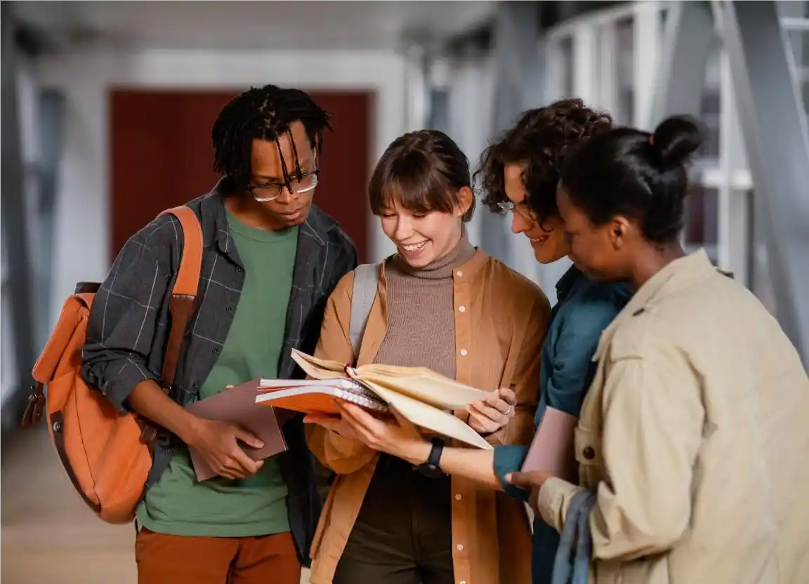 Quatro jovens em corredor, lendo livros e estudando no novo Ensino Médio